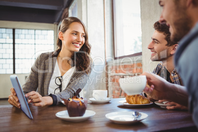 Smiling friends using tablet computer together