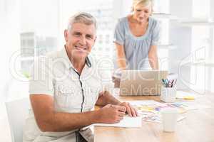 Smiling businessman writing on a notebook