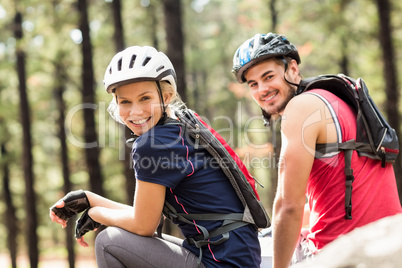 Young happy biker couple sitting on a rock