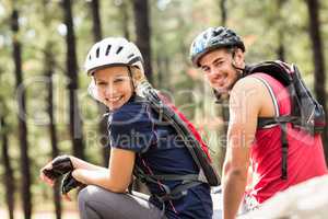 Young happy biker couple sitting on a rock