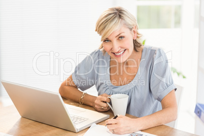 Smiling businesswoman working on a laptop