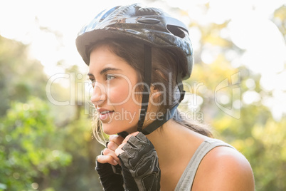 Athletic brunette putting on helmet
