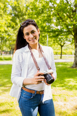 Beautiful brunette taking photo in the park