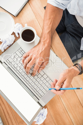 Hands working with blank screen laptop