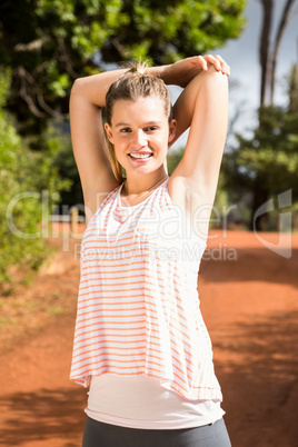 Smiling blonde athlete stretching arms