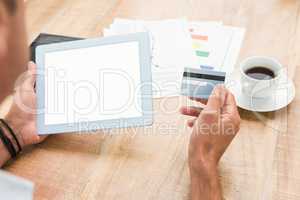 Casual businessman holding blank screen tablet and credit card