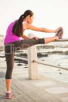 Fit woman stretching leg on railing