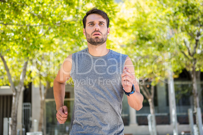 Handsome athlete running in the street