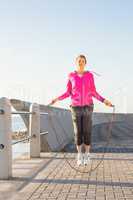 Sporty woman skipping at promenade