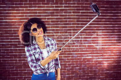 Attractive hipster taking selfies with selfiestick