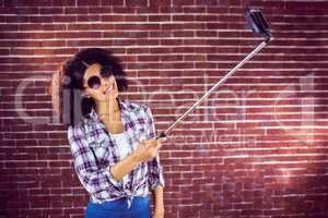 Attractive hipster taking selfies with selfiestick