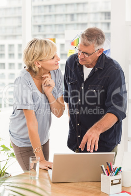 Attentive business team discussing over a laptop