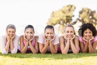 Smiling women lying in a row and wearing pink for breast cancer