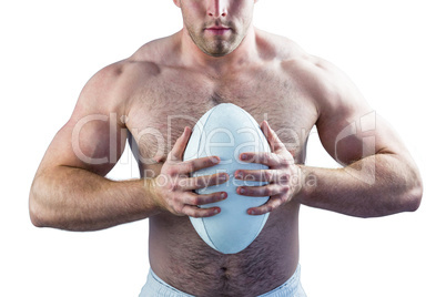 Shirtless rugby player holding ball