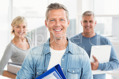 Smiling business colleagues holding workbooks