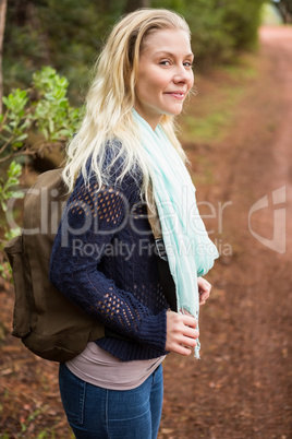 Smiling female hiker waiting by the side of the road