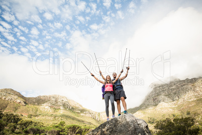 Young happy joggers standing on rock cheering