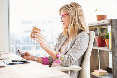 Smiling casual designer using smartphone