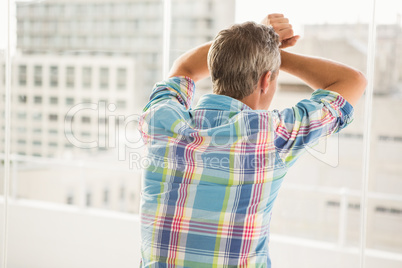 Rear view of troubled casual businessman leaning against window