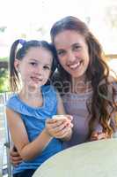 Mother and daughter enjoying cakes at cafe terrace