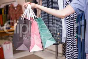 Woman holding shopping bags out