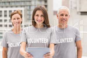 Smiling volunteers with tablet