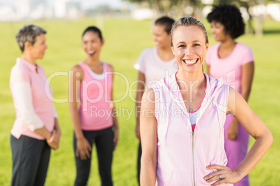 Smiling blonde wearing pink for breast cancer in front of friend