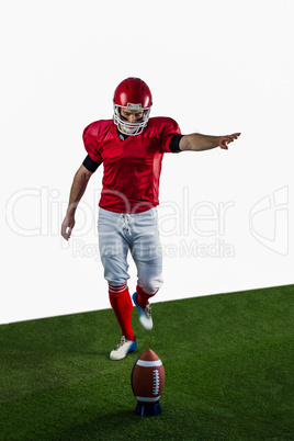 American football player kicking football