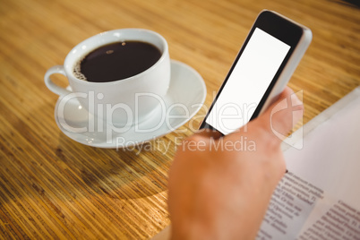 Man using smartphone and having coffee