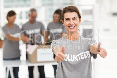Smiling female volunteer doing thumbs up