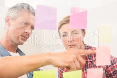 Casual business colleagues reading sticky notes