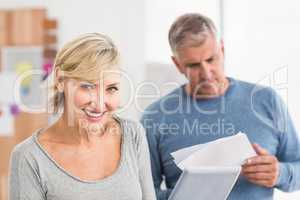 Smiling business colleagues reading and using tablet