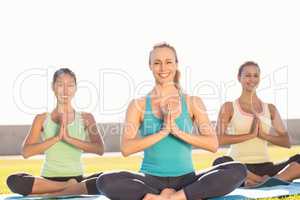 Smiling sporty women doing lotus pose
