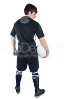 Back turned rugby player holding a ball