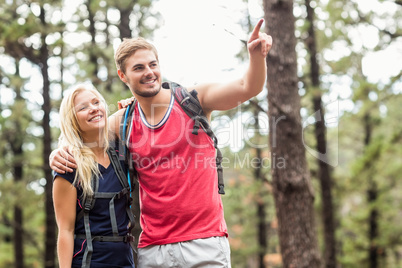 Happy young couple pointing at something