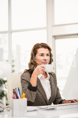 Casual businesswoman working and having coffee