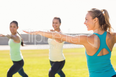 Yoga teacher and sporty women attending yoga class