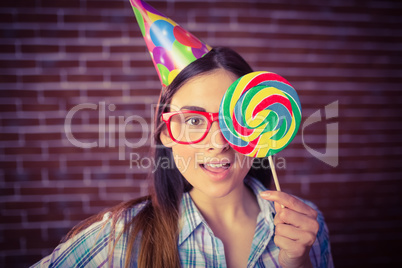 Pretty hipster with party hat and lollipop