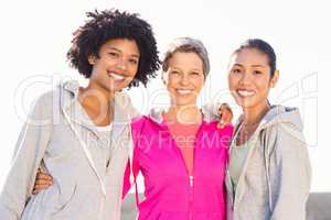 Smiling sporty women with arms around each other