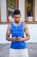 An handsome athlete using his phone