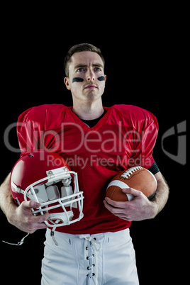 American football player holding helmet