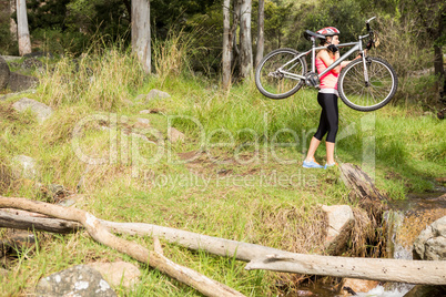 Blonde athlete carrying her mountain bike