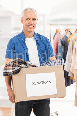 Smiling casual businessman holding donation box