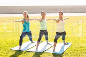 Smiling sporty women doing yoga together