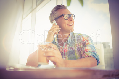 Smiling casual designer having a phone call Smiling casual designer having a phone call