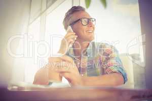 Smiling casual designer having a phone call