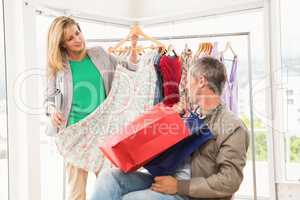 Woman showing dress to her sitting man