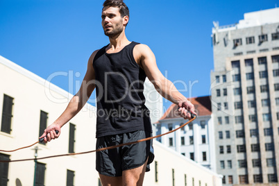 Handsome athlete doing jumping rope