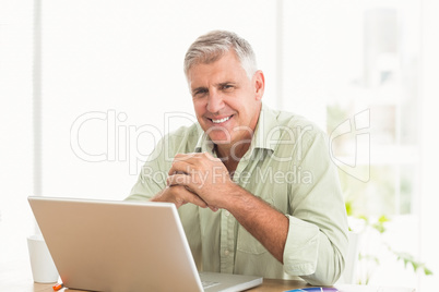 Smiling businessman working on a laptop