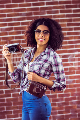 Attractive smiling hipster posing with camera